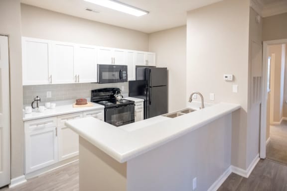 Spacious Kitchen with White Cabinetry and Black Appliances  at Polos at Hudson Corners Apartments, South Carolina 29650