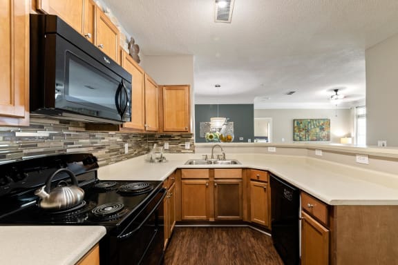 Model kitchen with cabinets at Sugarloaf Crossings Apartments in Lawrenceville, GA 30046