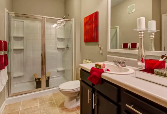 Bathroom, tile flooring, shower, toilet, vanity with solid surface countertops at Enclave at Bailes Ridge Apartment Homes, Indian Land, South Carolina