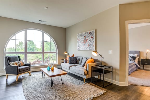 a living room with a large arched window and a couch and chair at Aspire Apollo, Maryland, 20746
