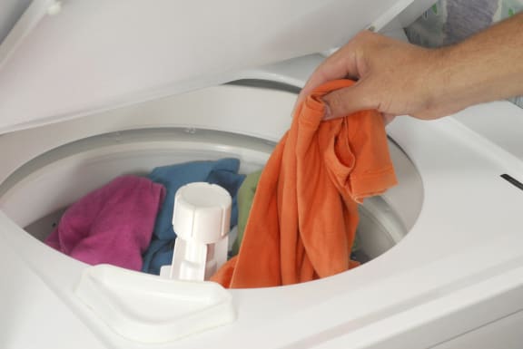Person putting clothes in washer machine-Tremont Pointe Apartments, Cleveland, OH 44113