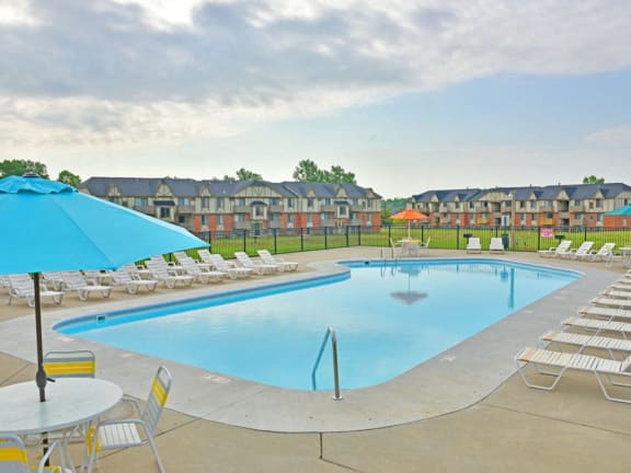 Outdoor swimming pool with sundeck at Grand Bend Club apartments in Grand Blanc, MI