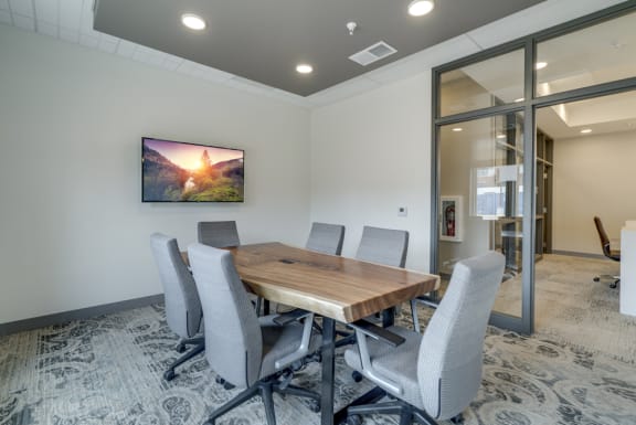 Conference room with table, office chairs, and television