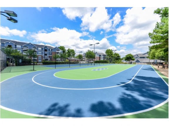 Lighted Tennis Court with Adjacent Sports Court at Sugarloaf Crossing Apartments, Lawrenceville, GA 30046