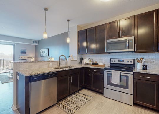 One bedroom apartment, kitchen stainless steel appliances, granite countertops, tile backsplash at The Axis, Plymouth, MN