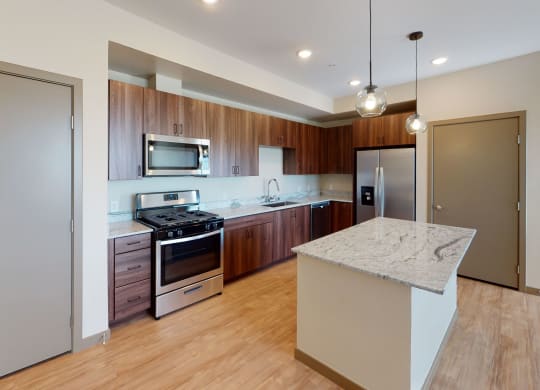 Modern kitchen complete with stainless steel appliances, kitchen island, and a pantry at Brownstone Apartments in Las Vegas, Nevada