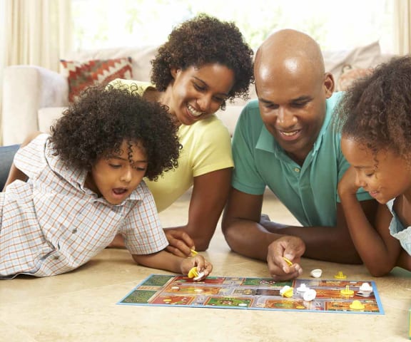 Family playing a board game l Cordova Apartments in Selma CA 