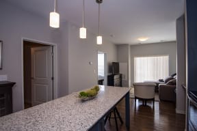 Large Kitchen Island with Granite Countertops and Pendant Lighting