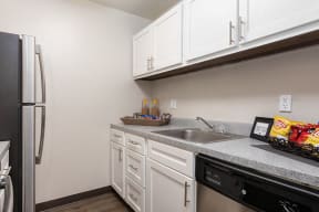 Kitchen with White Cabinetry and Stainless Steel Fridge, Dishwasher and Hardware