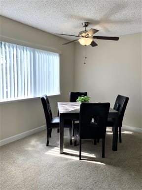 dining room with window, 4 seater dining table and ceiling fan