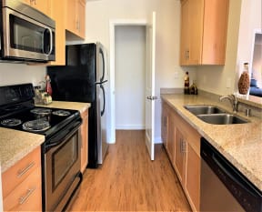 kitchen with black/stainless steel appliances such as refrigerator, dishwasher, microwave and stove/oven