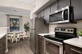 Apartment home with espresso cabinetry and stainless steel appliances| Lodge at Lakeline Village