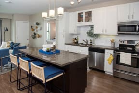 Furnished kitchen with center island, white cabinet finishes and stainless steel appliances