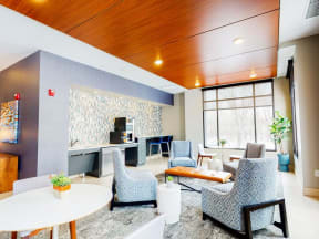 Lobby lounge with coffee bar, four blue lounge chairs and circular tables