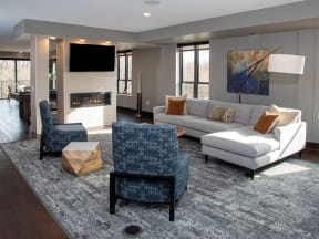 Community space with large sectional couch, fireplace and mounted flatscreen