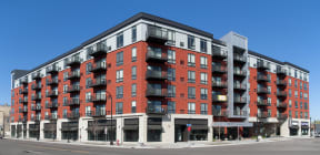 Exterior of Red 20 Apartments; a red and white building with black balconies.