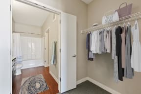 Large walk in closet with shelf storage and doors leading into the private master bathroom.