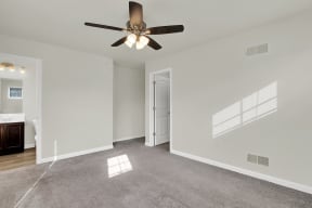 master bedroom grey carpet ceiling fan natural light