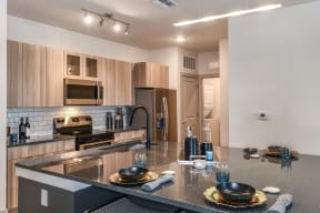 Coda Orlando's kitchen with hard flooring, wooden cabinets, and stainless steel appliances in Orlando, FL