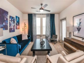 Furnished living room with carpet flooring and access to private patio in Coda Orlando apartments in Orlando, FL