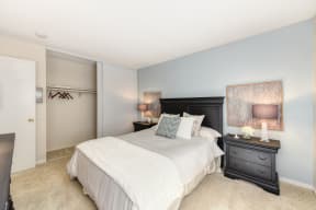 Master bedroom in the model home. Queen size bed with two nightstands. Large closet and carpeting on the floors.