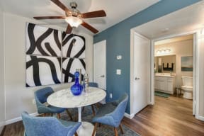 Dining Area with storage closet, Blue Chairs, Small, Round White Table, Ceiling Fan/Light and Abstract Painting on Wall