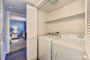 Full Size In Unit Washer Dryer with View of Bedroom and White Walls