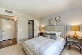 Bedroom with Large Extended Closet, Carpet, Lamps and Abstract Painting Above Bed