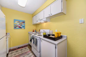 Kitchen with Stove with Yellow Walls, Stove, Hardwood Inspired Floor and White Cabinets