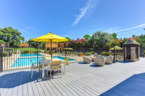 Pool Lounge  Area  with Yellow Umbrellas, Grills, Wicker Chairs, Gates with View of Pool