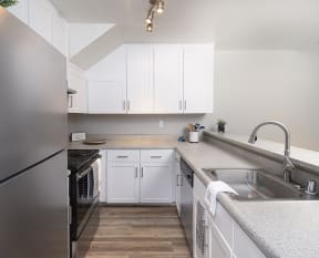 Updated kitchen with white cabinetry and stainless steel appliances
