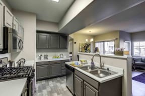Apartments in Henderson - Tesoro Ranch Kitchen with Matching Stainless Steel Aplliances, Spacious Countertops, and Double Sink