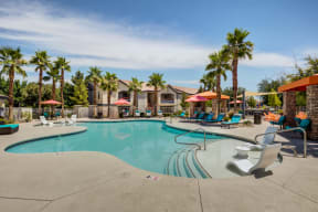 Apartments in Henderson, NV - Tesoro Ranch Swimming Pool Surrounded by Palm Trees and Lounge Chair Seating