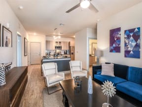 Furnished living room with wood floors and access to kitchen in Coda Orlando apartments in Orlando, FL