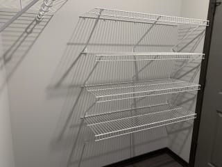 Haven-At-Uptown-Lincoln-NE-two-bedroom-apartment-Cloud-Mocha-finish Walk in closet with one full wall of wire wracks for storage and hanging