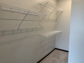 Walk in closet with one full wall of wire wracks for storage and hanging