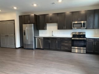 Open kitchen with matching stainless steel appliances in Peace floorplan at Haven at Uptown