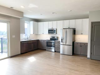 Spacious open kitchen with matching steel appliances and under cabinet lighting