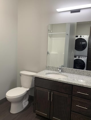 Haven-at-Uptown-Apartments-Lincoln-NE-Studio-Zen-Mocha Bathroom with dark brown vanity with storage and large mirror at Haven at Uptown