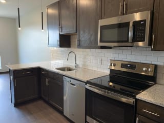 Haven-at-Uptown-Apartments-Lincoln-NE-Studio-Zen-Mocha Kitchen with matching stainless steel appliances in Zen floorplan at Haven at Uptown