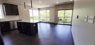 Haven-at-Uptown-Lincoln-NE-2-bedroom-apartment-Aura-Mocha-finish-16 Kitchen with connected living and dining area with windows to let in natural light