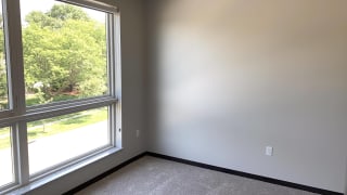 Bedroom with floor to ceiling windows looking out to park in north Lincoln