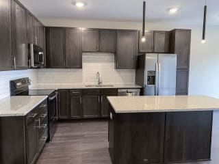 kitchen with lots of storage cabinets in a warm mocha finish at Haven at Uptown