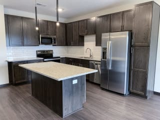 kitchen with lots of storage cabinets in a warm mocha finish at Haven at Uptown