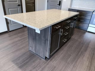 Haven-at-Uptown-Lincoln-NE-Bliss-Mocha-finish-one-bedroom-apartment-05 Kitchen island with light granite counters, warm mocha cabinets and storage