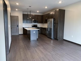 Living area looking into connected kitchen with island at Haven at Uptown