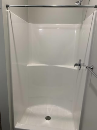 Walk in shower with curtain rod in a studio floor plan at Haven at Uptown