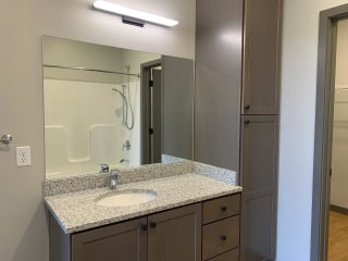 spacious bathroom with large mirror in light gray finish at Haven at Uptown in Lincoln, Nebraska