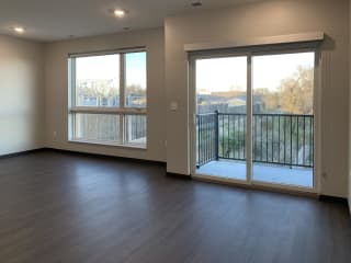living and dining area with large window and balcony access