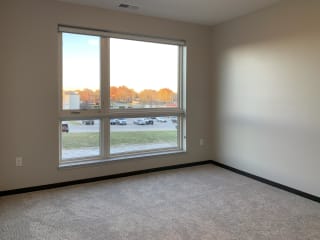 carpeted master bedroom with large floor to ceiling window